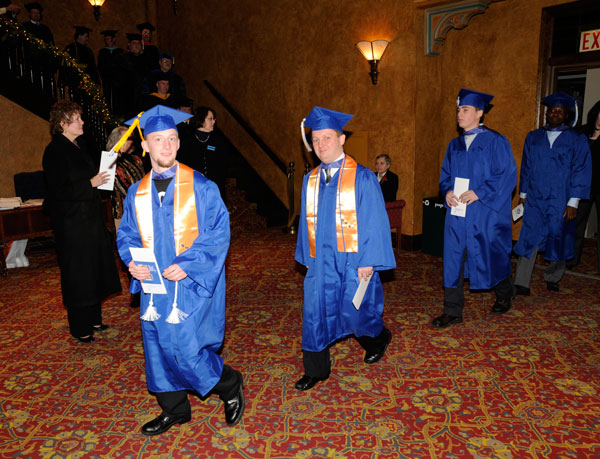 Soon-to-be-graduates cross the Community Arts Center foyer.
