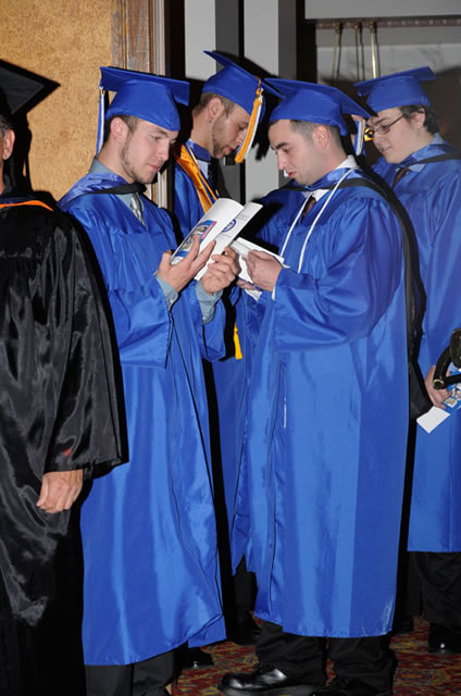 Checking the programs, during a lull in the procession