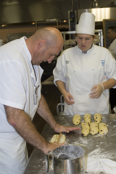 Visiting baker Dominique Homo offers guidance to baking and pastry arts student Kayla Shultz.
