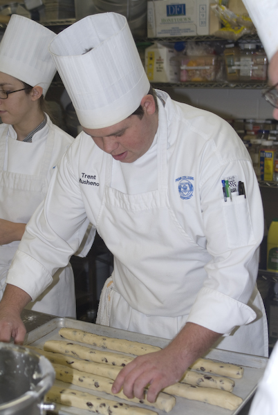Baking and pastry arts student Trent Musheno shapes raisin-cookie dough.