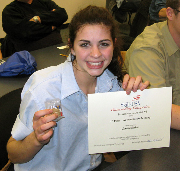... and displays her first-place certificate and medal in automotive refinishing