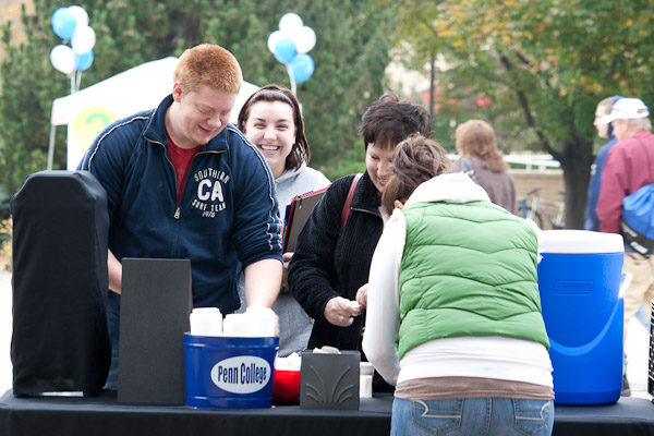 Families enjoy warming up with free, hot drinks at the beverage station on the campus mall.
