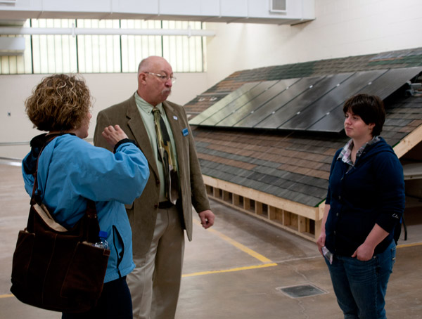 Richard M. Sarginger, instructor of building construction technology, explains the renewable energy technologies laboratory to a prospective student, aided by Sarah S. Moore, sign language interpreter/student support assistant with Disability Services.