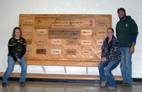 A hit with visiting forestry majors was this display of northern and central Pennsylvania forest samples, crafted by current students Kayla L. Kehres, of Roaring Branch, left, and Laurie A. Nau, of Jersey Shore; and begun last year by now-alumnus Dustin L. Rhoades, the most recent graduate to attend the forestry reunion, at right.
