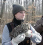 Forestry student Shannon L. Emig holds a screech owl that was found in one of the hundreds of wooden nests built by students and installed on the property