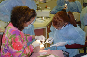 Susan L. Hughes, part-time instructor of dental hygiene, left, and Lyndsey N. Root, a dental hygiene-health policy and administration student from Linden, examine a child's mouth at Pennsylvania College of Technology's dental hygiene clinic during 'Sealant Saturday.'
