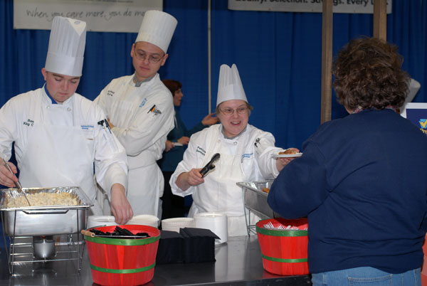 From left, School of Hospitality students Benjamin A. King, Arthur H. Byra and Patricia A. Bennett serve a "Mushroom Day" dish to the public.