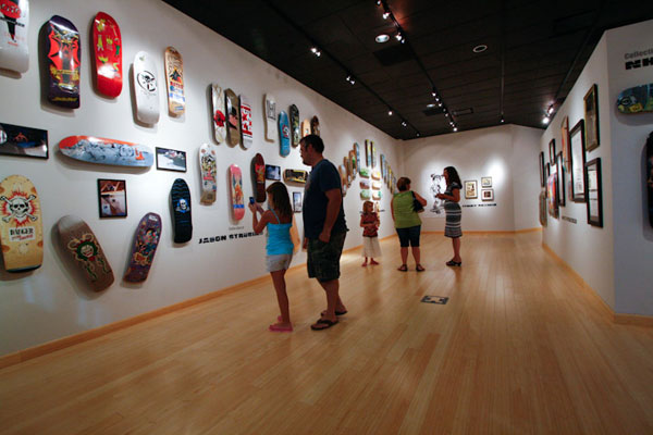 Gallery patrons move among hundreds of colorful creations.