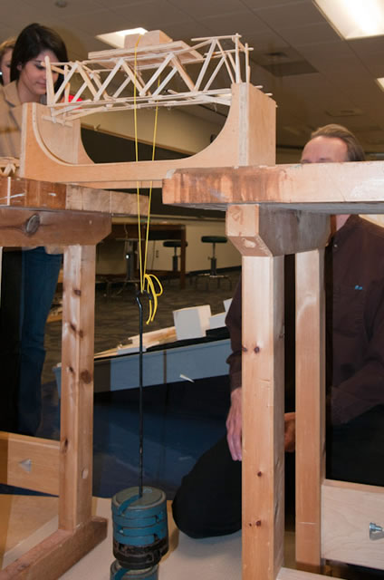 A bridge holds 11 pounds before breaking to tie for top place in a bridge-building competition in the architecture lab.