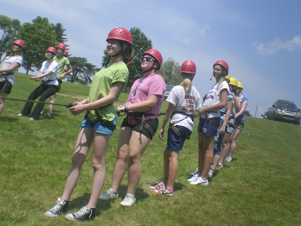 On the ground, belay teams support their climbing partners. 