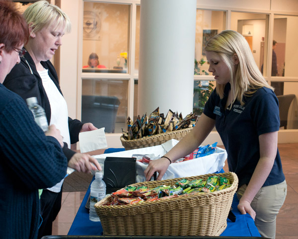 Student Ambassador Skylar K. Burke hands out travel snacks to Open House visitors near the Admissions Office.