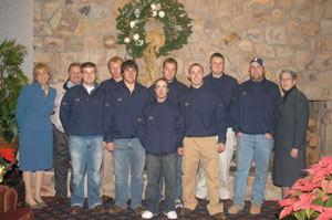 Dr. Landesberg-Boyle and Dr. Gilmour join the golf team in front of the fireplace.