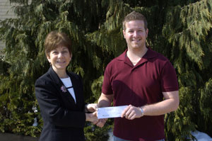Joann Kay, executive director of the Penn College Foundation, accepts a check for the Student Leader Legacy Scholarship Fund from James Riedel, Student Government Association president.