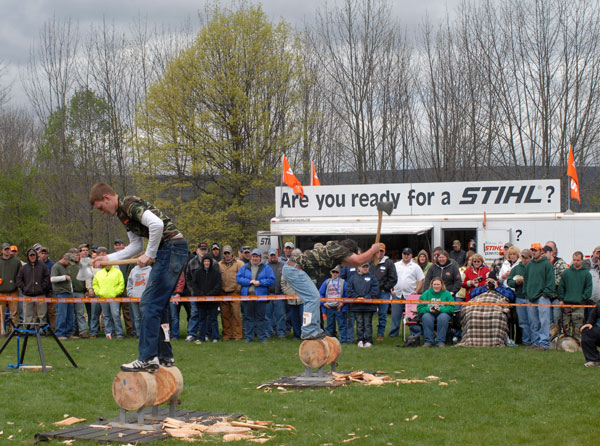 Penn College students Matthew A. Daubert, left, and Cody J. Fye wield axes for a Stihl Timbersports audience.