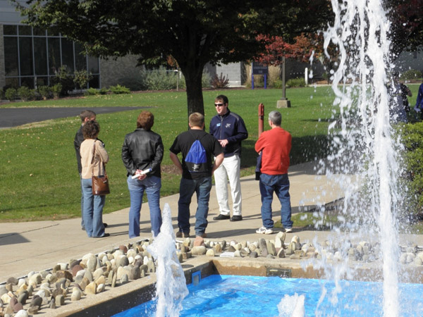 Framed by the dancing waters of the Veterans Fountain, Student Ambassador Kevin E. Brookhart leads a small group tour.