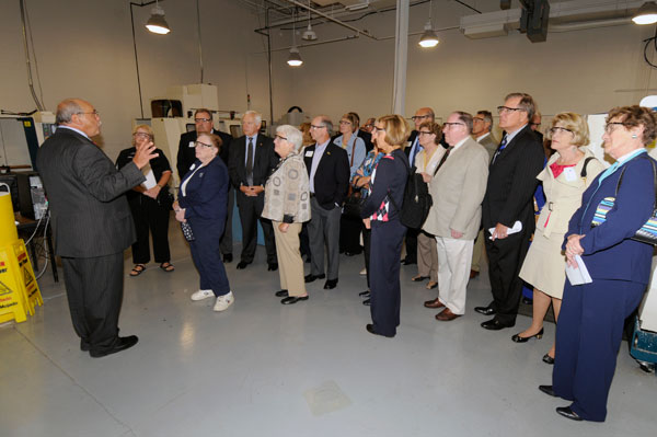 Guests don safety glasses for a tour of the automated manufacturing lab with Donald O. Praster, dean of industrial and engineering technologies.