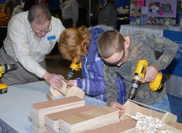 Steven K. McCoy, coordinator of matriculation and retention for the School of Construction and Design Technologies, helps 10-year-old twins Elizabeth and Micah Hillegass, of Dauphin.