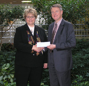 Debra M. Miller, Pennsylvania College of Technology's director of corporate relations, accepts a scholarship check from Scott Walp, manager of human resources for Victaulic, outside the company's Easton headquarters.