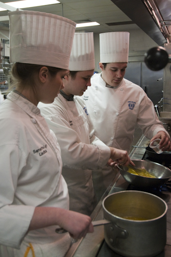 Students Samantha Liedtka, Samuel Bickle and Todd Unger prepare a sauce.