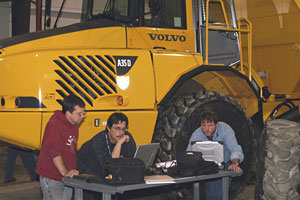 A three-member team of technicians uses laptop computers to help troubleshoot %22bugs%22 in a Volvo A35D articulated hauler during the %22Master Cup%22 competion at Pennsylvania College of Technology's Schneebeli Earth Science Center near Allenwood.