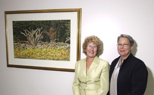  Charline M. Pulizzi (left) and Penn College President Dr. Davie Jane Gilmour are shown with the David Armstrong painting, 'Stump Fence Row.'