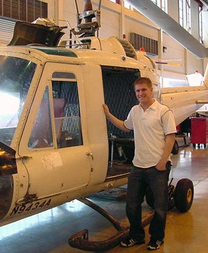 Scholarship recipient Wesley C. Miller, beside a Bell UH-1B helicopter at Penn College's Lumley Aviation Center in Montoursville. (Photo by William F. Stepp III, associate professor of aviation)