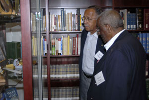 An alumnus and guest look at a display in the college archives.