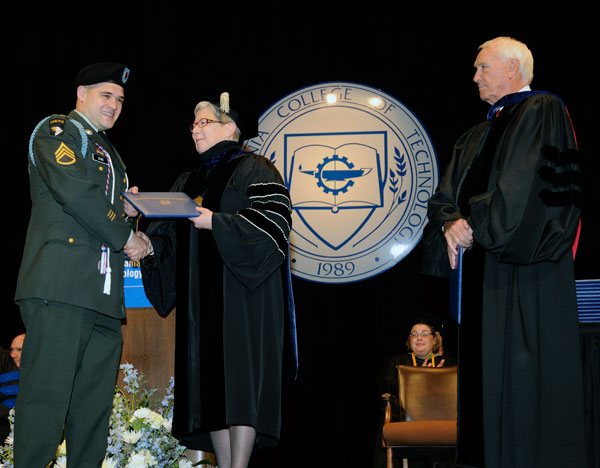 Staff Sgt. Donald R. Zerbe, his uniform complemented by the college's new honor cord for veterans, receives his diploma from President Davie Jane Gilmour.