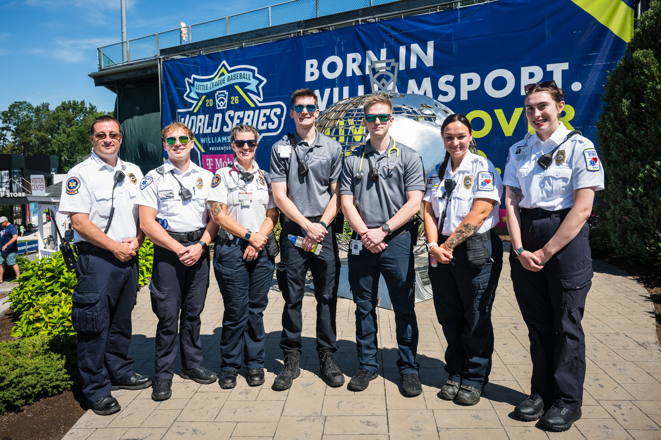 Seven people in paramedic uniforms pose outside Volunteer Stadium at Little League International.