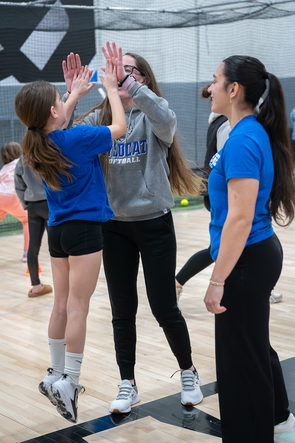 A girl jumps to give high fives to a college student-athlete.