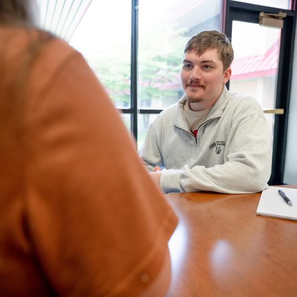 Male student practices intervention techniques with an anonymous person in the foreground.