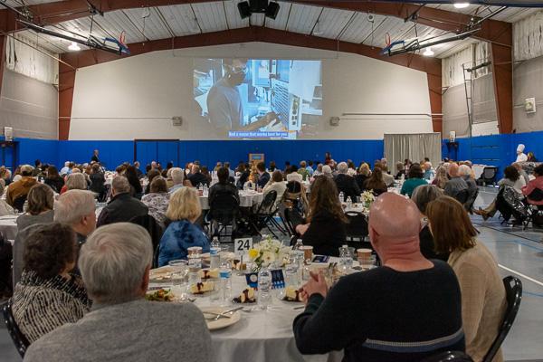 The large crowd falls silent and is intensely engaged as a video of Patel plays, sharing his inspiring life story. 