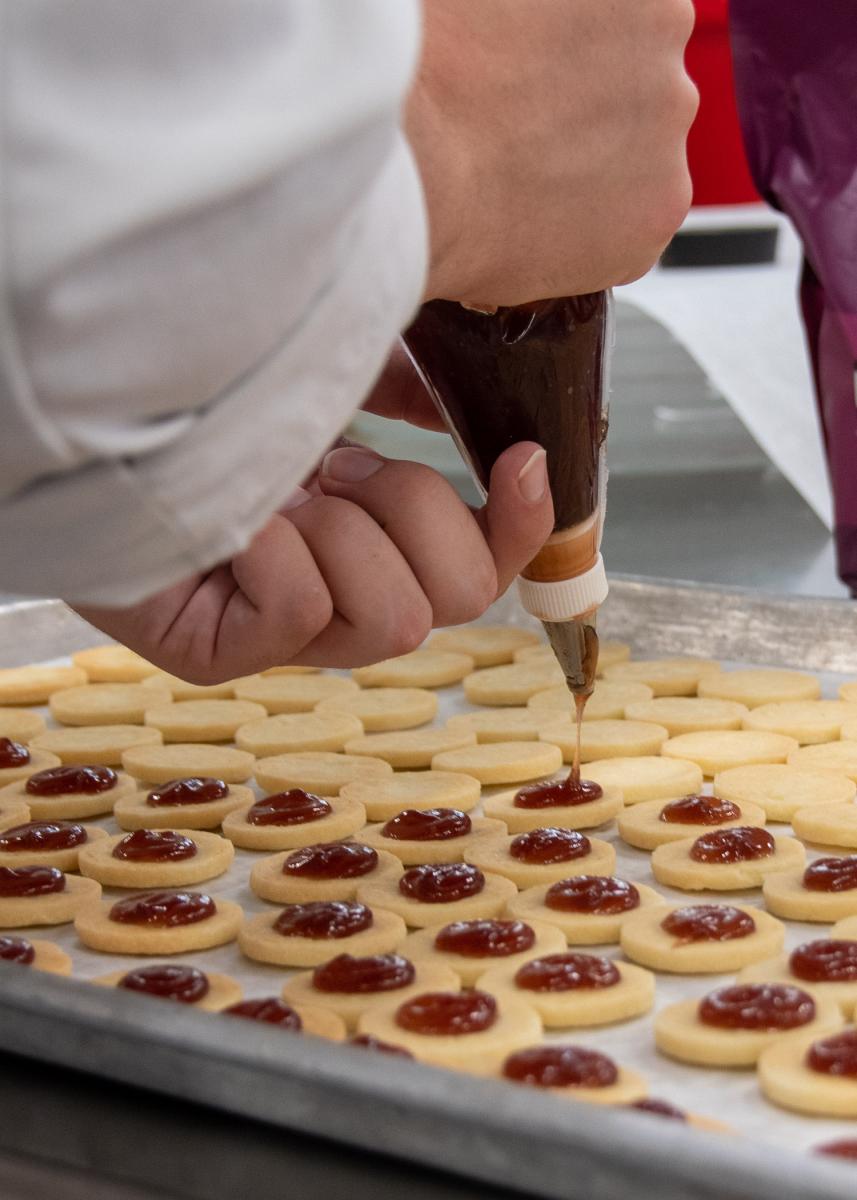 Carter P. Gordon, of Lancaster, adds raspberry jam to mini Linzer tortes. Gordon is pursuing a certificate in professional baking.