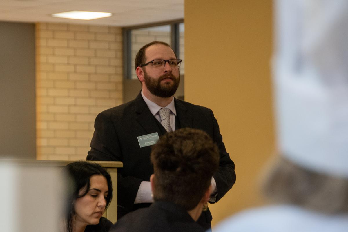Brian D. Walton, assistant dean of business and hospitality, opens the “lineup” – during which front-of-house and back-of-house staff gather with the chefs to review the evening’s menu and order of service.