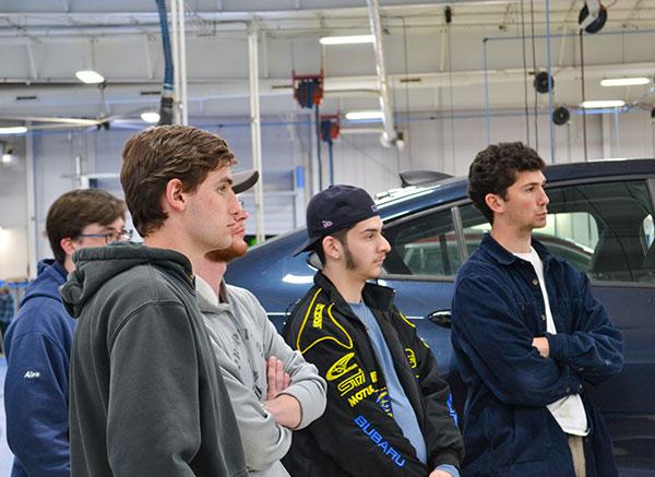 Automotive students listen intently at one of the information stations.