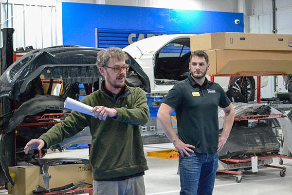 Matt Corbett (left), collision technician, and Quintin Helm, a Penn College alumnus and Blaise Alexander's recon manager, speak with students about job opportunities and internships. Helm, who earned an associate degree in collision repair technology in 2016, serves on the program's advisory committee.