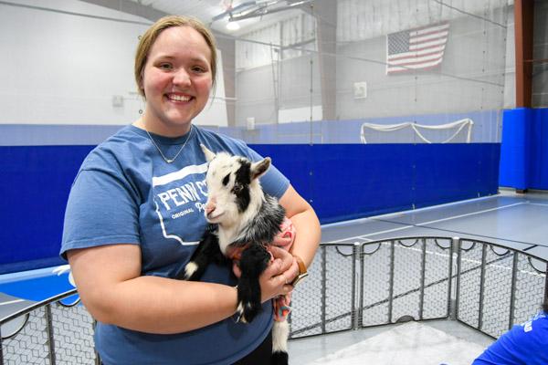 Emily L. Fink, of Jersey Shore, holds her yoga partner. As one of the first four students to arrive, the human services & restorative justice student got to feed one of the "bottle babies" and was a goat magnet the entire evening.