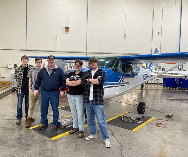 ... and stands at the center of a group of students in Stepp's Aviation Science II class. From left are Brayden A. Yount, of Winfield; Ryan G. Kothe, of Harrisburg; Gable; Lilia M. Crowder. of Shippensburg; and Sean McGovern, of Middletown.