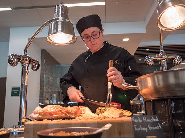 Pennsylvania College of Technology student Cynthia Setzer, who earned a Penn College degree in baking and pastry arts in 2018 and applied management in 2020, carves meat for a buffet in Churchill Downs’ Turf Club during the 2018 Kentucky Derby. Continuing a 30-year partnership, Penn College students will return to Churchill Downs’ kitchens for the 2023 Kentucky Derby. 