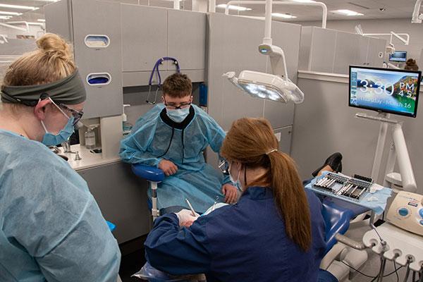 Ford observes in the Dental Hygiene Clinic, where Penn College student Cameryn Sock (left) watches as Tammy S. Clossen, assistant professor of dental hygiene, checks her work.