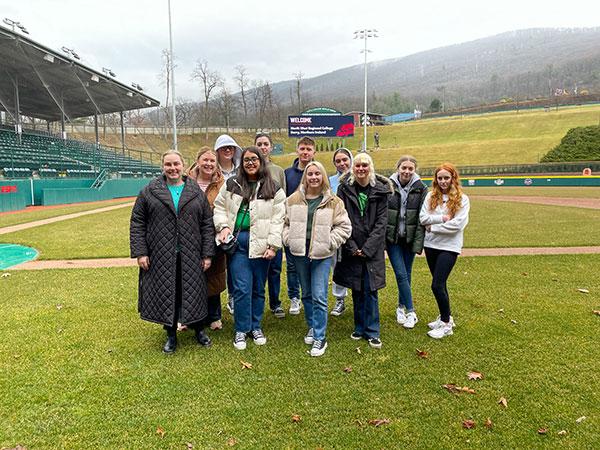 The group ventures into Howard J. Lamade Stadium, where a "welcome" message accompanies their trip to the real-life field of dreams.
