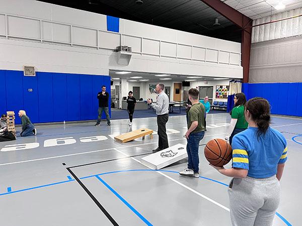 Reed is in the center of the Field House action, which offered a game-filled respite through hoops, Jenga and cornhole. Standing at rear are Jeremy R. Bottorf, coordinator of campus recreation, and Kaylena L. Harrell, a campus recreation student assistant enrolled in graphic design.