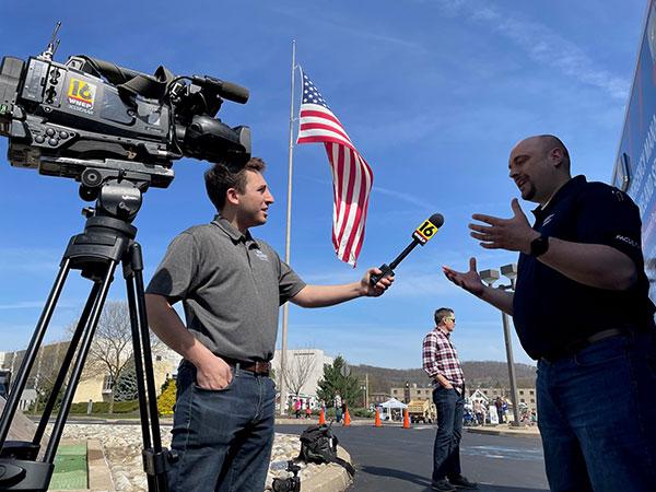 Chris Keating, Central Pennsylvania Bureau reporter for WNEP, talks with instructor William A. Schlosser near the Rotorfest staging area off Penn College's Maynard Street entrance. Standing in the background is David E. Bjorkman, instructor of emergency management/social science.
