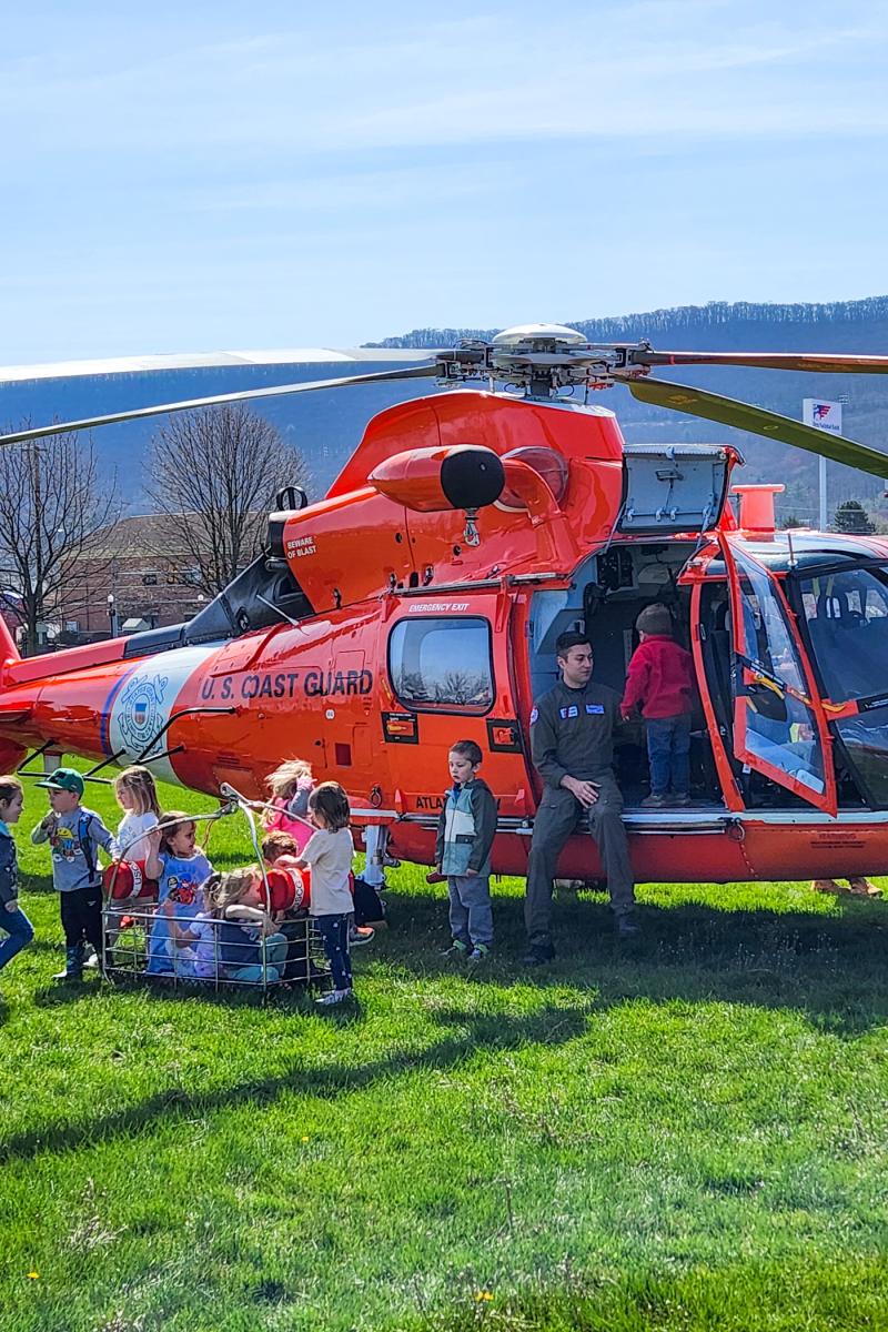 Delighted to be temporarily taking charge of the Coast Guard helicopter are the littlest ones on campus – kids from the Children’s Learning Center. 