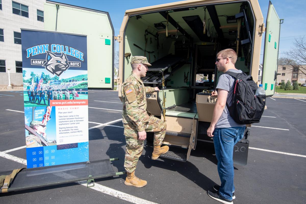 Pfc. Cade Shower (left), of the U.S. Army 337th Engineering Unit based in Danville, shows an Army ambulance to Jared L. Critchfield, an engineering design technology student from Somerset. 