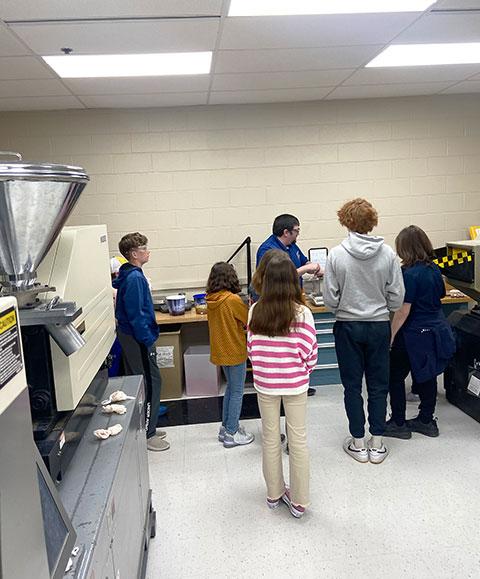 ... while faculty colleague Adam C. Barilla enlightens visitors in another plastics lab.