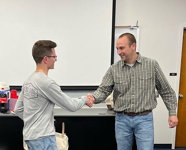 Nathan Totsky is congratulated by Kevin Yokitis, assistant professor of electrical technology/occupations.