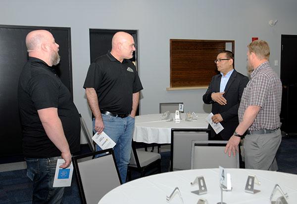Graduate Pinalkumar Patel (second from right) talks with his co-workers from The Ames Cos. (left) and Christopher D. Gramling, industrial training specialist.