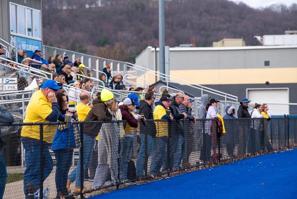 Yellow-clad and bundled-up supporters line the field fence.