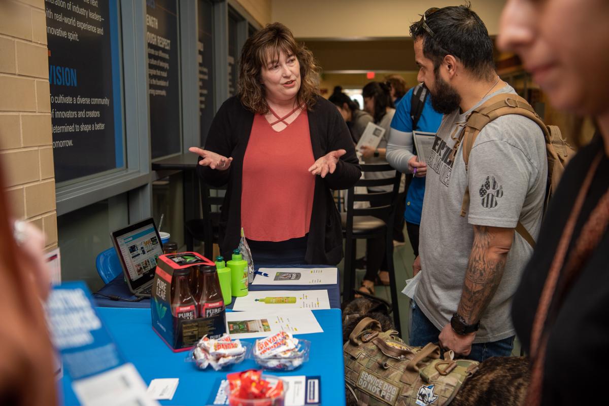 Renee Y. Bitler, assistant to college relations, discusses smart-shopping consumer goals with Raul A. Carabajal, human services & restorative justice.